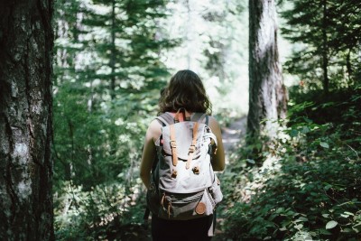 Woman hiking through the forest with a backpack